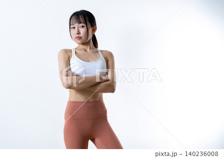 腕組みしてポージングする若い女性 鍛えてかっこいい筋トレ女子 自信 レギンス トリミングアップ 腕組みしてポージングする若い女性 鍛えてかっこいい筋トレ女子 自信 レギンス トリミングアップ 140236008