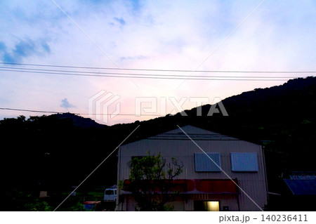【香川】夏の女木島　女木島海岸から望む夕焼けと街並み 140236411
