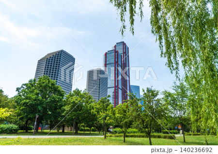Seoul, South Korea - May. 24, 2026 : Scenic view of Yeouido financial district skyscrapers framed by lush green trees at Yeouido Park in Seoul, South Korea 140236692