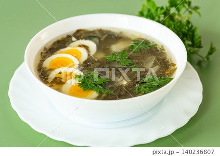 traditional green borscht with sorrel and eggs in a white plate traditional green borscht with sorrel and eggs in a white plate 140236807