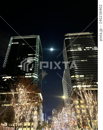 イルミネーション輝く高層ビル群の夜空に浮かぶ満月 140236902