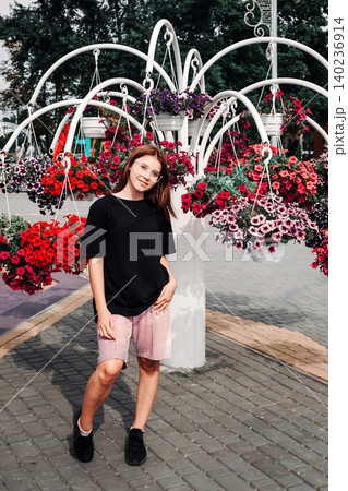 teenage girl stands against a flower construction teenage girl stands against a flower construction 140236914