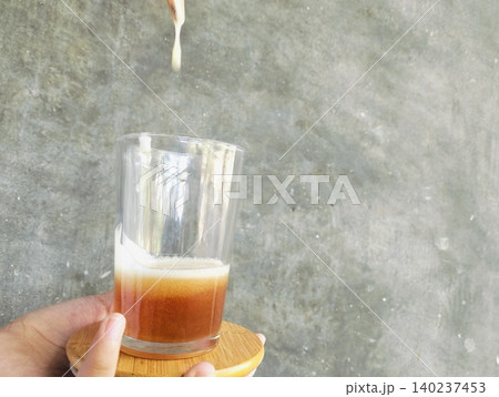 Hands Holding Glass Jar of Honey and Wooden Spoon on Concrete Background Hands Holding Glass Jar of Honey and Wooden Spoon on Concrete Background 140237453