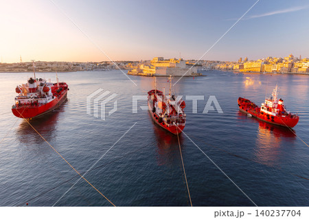 Red tanker ships in Grand Harbour at sunrise in Valletta Malta 140237704