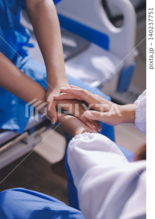 Gentle Hand Holding by Healthcare Worker in Teal Scrubs Offering Comfort and Support in Bright Modern Medical Office with Light Gray Background Gentle Hand Holding by Healthcare Worker in Teal Scrubs Offering Comfort and Support in Bright Modern Medical Office with Light Gray Background 140237751