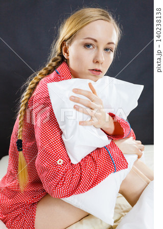 Sad depressed girl in bed gripping pillow Sad depressed girl in bed gripping pillow 140238138