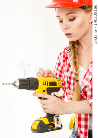 Woman using drill on ladder Woman using drill on ladder 140238166