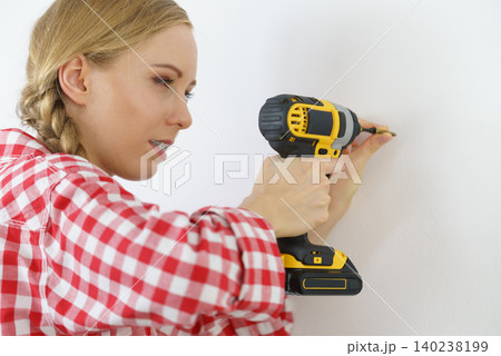 Woman drilling in wall 140238199