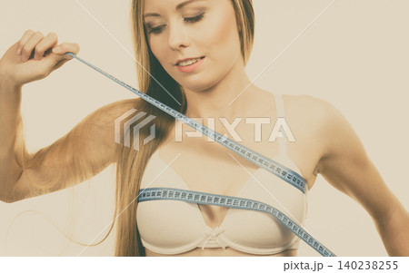 Girl measuring her chest breasts bust size Girl measuring her chest breasts bust size 140238255
