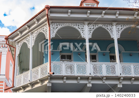 Traditional Wooden Balcony with Intricate Lacework Carvings and Decorative Veranda Details 140240033