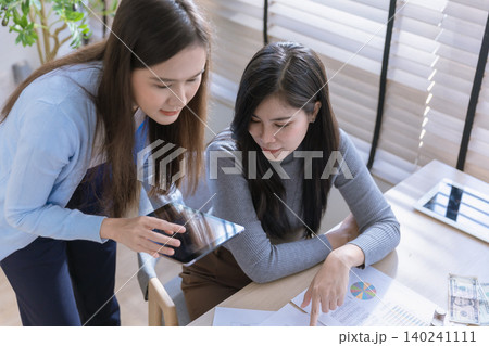 Team of partners Asian business woman discussing project on laptop sitting at table in office. Team of partners Asian business woman discussing project on laptop sitting at table in office. 140241111