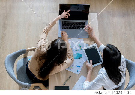Team of partners Asian business woman discussing project on laptop sitting at table in office. Team of partners Asian business woman discussing project on laptop sitting at table in office. 140241130