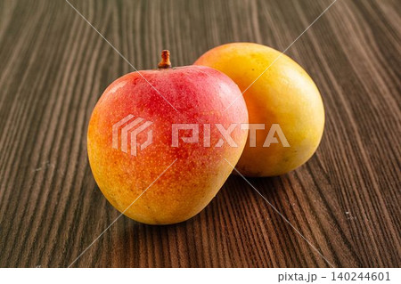 Ripe mangoes on wooden surface Ripe mangoes on wooden surface 140244601