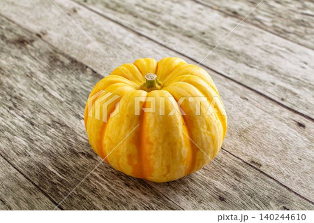 Small yellow pumpkin on rustic wooden table Small yellow pumpkin on rustic wooden table 140244610
