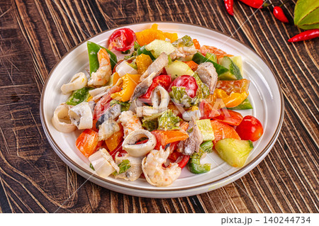Seafood salad with squid rings and shrimp on a white plate Seafood salad with squid rings and shrimp on a white plate 140244734