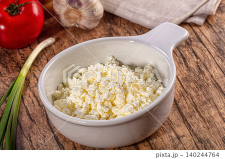 Bowl of fresh cottage cheese with tomato, garlic and spring onion on a wooden table Bowl of fresh cottage cheese with tomato, garlic and spring onion on a wooden table 140244764