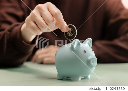 Hand dropping Coin into Piggy bank. Saving money, financial discipline Hand dropping Coin into Piggy bank. Saving money, financial discipline 140245280