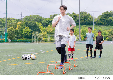 フットサル練習でラダートレーニングを行う少年たちと男性コーチ 140245499