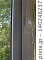 Modern white uPVC window. The focus is on the frame, the ergonomic handle, and the beaded pull chain for a pull-down blind. The handle is positioned for right-hand use 140248237
