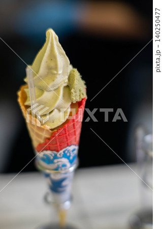 ワッフルコーンに入った美味しそうな抹茶ソフトクリーム ワッフルコーンに入った美味しそうな抹茶ソフトクリーム 140250477