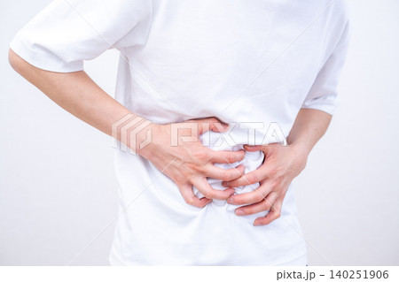 腹痛でお腹を押さえる男性 140251906