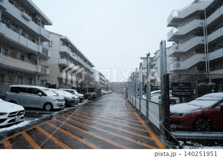 雪が降る集合住宅の駐車場 140251951