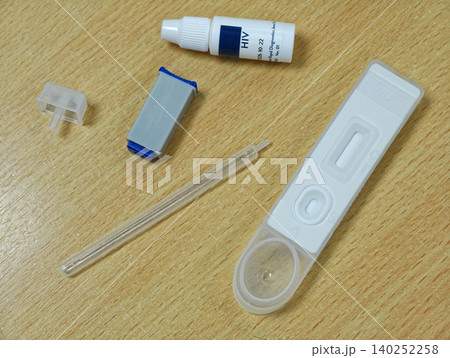 HIV Self Testing Kit on Wooden Surface test strip tube plastic medical device clinical home health neutral HIV Self Testing Kit on Wooden Surface test strip tube plastic medical device clinical home health neutral 140252258