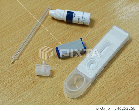 HIV Self Testing Kit on Wooden Table plastic white blue clear pipette health medical diagnosis disease 140252259