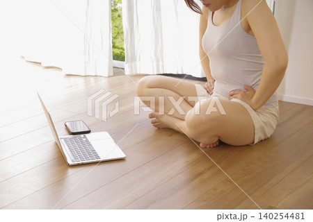 床に座って上半身のストレッチを行う女性 床に座って上半身のストレッチを行う女性 140254481