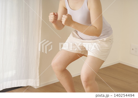 自宅でスクワット運動をする女性 140254494
