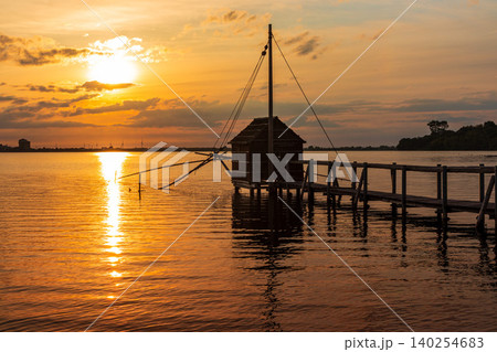 夕焼けに染まる湖と四手網漁の監視小屋のある風景 夕焼けに染まる湖と四手網漁の監視小屋のある風景 140254683