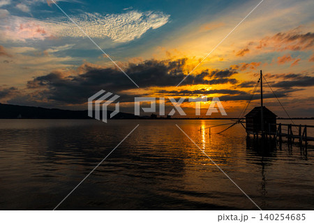 夕焼けに染まる湖と四手網漁の監視小屋のある風景 夕焼けに染まる湖と四手網漁の監視小屋のある風景 140254685