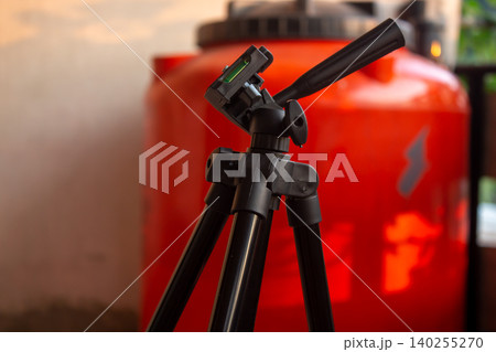 Black Camera Tripod with Blurred Background Photography Equipment Close Up 140255270
