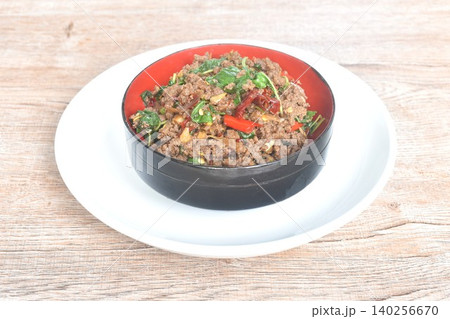 spicy stir fried chop beef meat with chili and basil in bowl on plate spicy stir fried chop beef meat with chili and basil in bowl on plate 140256670
