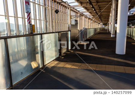 朝日が差し込む新幹線駅のホームと可動式ホーム柵(ホームドア)の風景 朝日が差し込む新幹線駅のホームと可動式ホーム柵(ホームドア)の風景 140257099