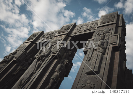 Dramatic Low Angle View of Monumental Stone Gateway with Historical Reliefs 140257155