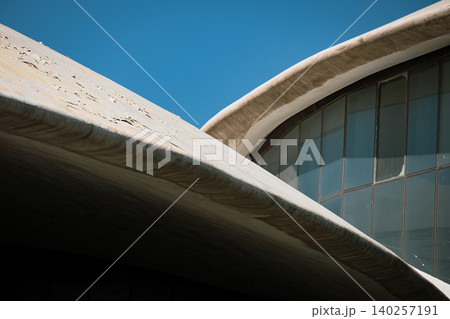 Abstract Modern Architectural Curves and Glass Facade Against Blue Sky Abstract Modern Architectural Curves and Glass Facade Against Blue Sky 140257191