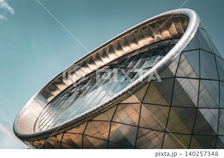 Futuristic Curved Glass and Metal Building Facade with Geometric Panels 140257348