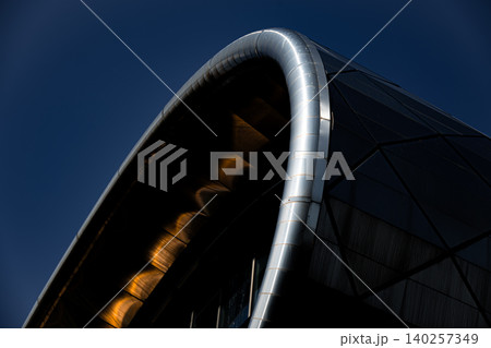 Futuristic Curved Glass and Metal Building Facade with Geometric Panels Futuristic Curved Glass and Metal Building Facade with Geometric Panels 140257349