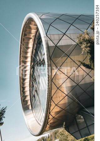 Futuristic Curved Glass and Metal Building Facade with Geometric Panels 140257384