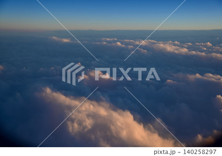 Looking through the airplane window with the sunset sky. Romantic sky, golden hours, colorful sunset sky with clouds. Stunning cloudscape and skyscape. Nature concept. For background use. Looking through the airplane window with the sunset sky. Romantic sky, golden hours, colorful sunset sky with clouds. Stunning cloudscape and skyscape. Nature concept. For background use. 140258297