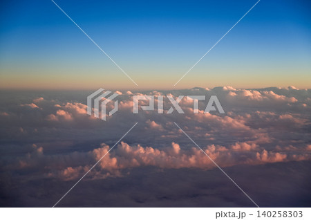Looking through the airplane window with the sunset sky. Romantic sky, golden hours, colorful sunset sky with clouds. Stunning cloudscape and skyscape. Nature concept. For background use. 140258303