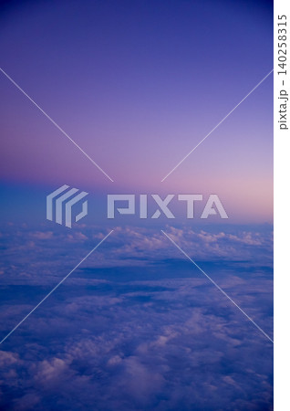 Looking through the airplane window with the sunset sky. Romantic sky, golden hours, colorful sunset sky with clouds. Stunning cloudscape and skyscape. Nature concept. For background use. Looking through the airplane window with the sunset sky. Romantic sky, golden hours, colorful sunset sky with clouds. Stunning cloudscape and skyscape. Nature concept. For background use. 140258315