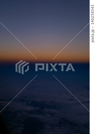 Looking through the airplane window with the sunset sky. Romantic sky, golden hours, colorful sunset sky with clouds. Stunning cloudscape and skyscape. Nature concept. For background use. Looking through the airplane window with the sunset sky. Romantic sky, golden hours, colorful sunset sky with clouds. Stunning cloudscape and skyscape. Nature concept. For background use. 140258343