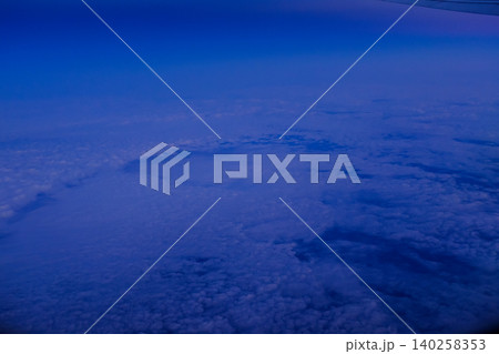 Looking through the airplane window with the sunset sky. Romantic sky, golden hours, colorful sunset sky with clouds. Stunning cloudscape and skyscape. Nature concept. For background use. Looking through the airplane window with the sunset sky. Romantic sky, golden hours, colorful sunset sky with clouds. Stunning cloudscape and skyscape. Nature concept. For background use. 140258353