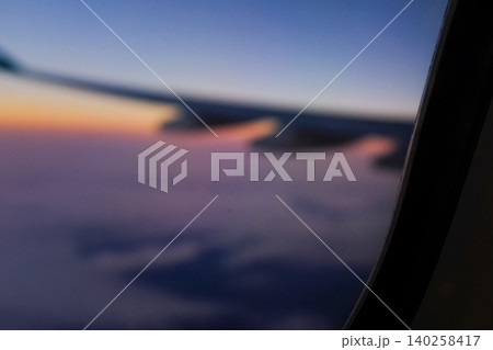Sunset sky from the airplane window in blur. Romantic sky, golden hours, colorful sunset sky with clouds. Stunning cloudscape and skyscape. Nature and travel concept. For background use. 140258417