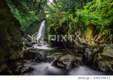 Aerial view of a hidden waterfall deep within the lush tropical rainforest of Mount Daun Aerial view of a hidden waterfall deep within the lush tropical rainforest of Mount Daun 140258611
