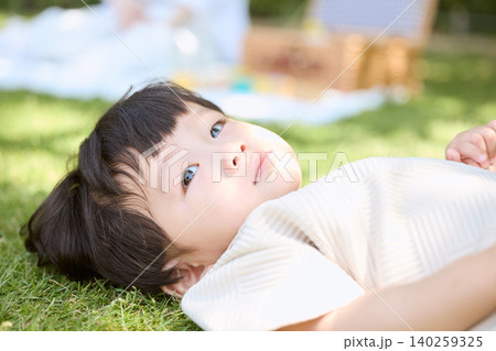 芝生に寝転んで空を見上げる幼い男の子 芝生に寝転んで空を見上げる幼い男の子 140259325