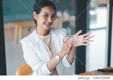 Cheerful businesswoman clapping during office meeting, showing approval, encouragement and positive response to a presentation or successful team discussion in a modern workplace. Cheerful businesswoman clapping during office meeting, showing approval, encouragement and positive response to a presentation or successful team discussion in a modern workplace. 140259890