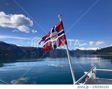 ノルウェーのフィヨルドを背景になびくノルウェー国旗 ノルウェーのフィヨルドを背景になびくノルウェー国旗 140260282
